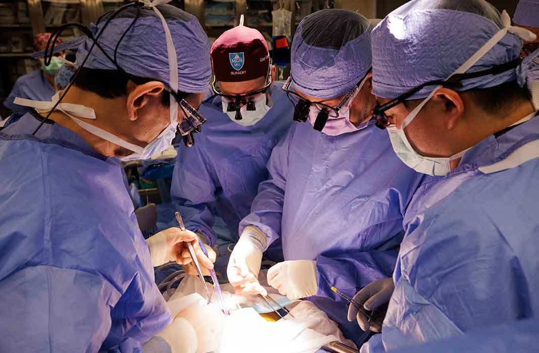 surgeons in the operating room performing transplant on patient