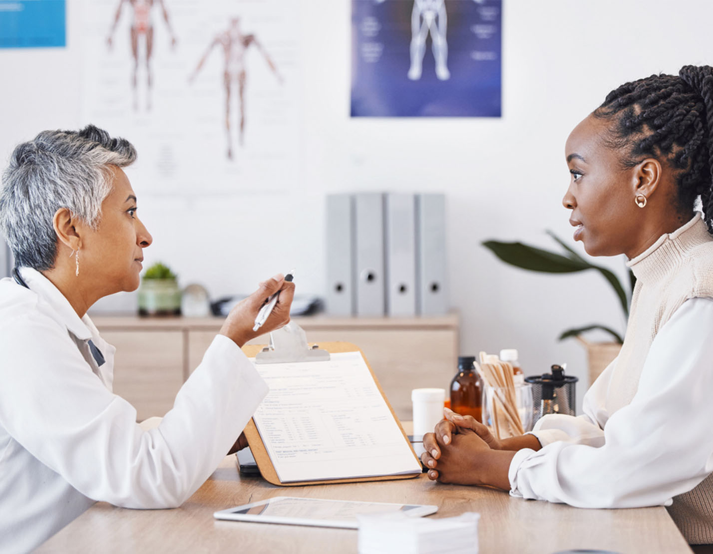 female african american patient talking to female doctor in office 