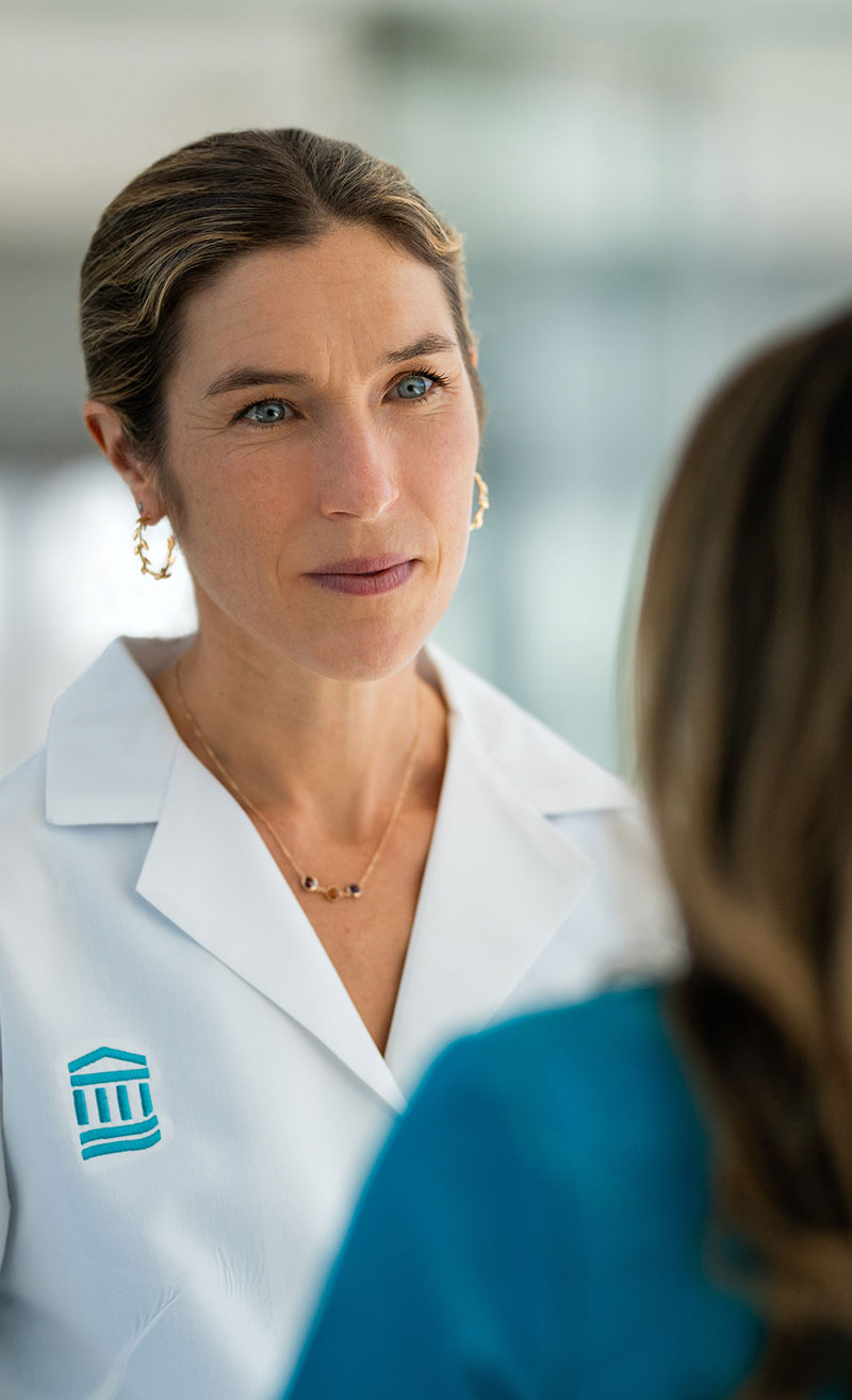 Dr. Sarah Wakeman speaking with clinician in hallway