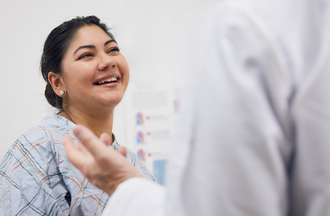 A woman smiling  in a doctor's office