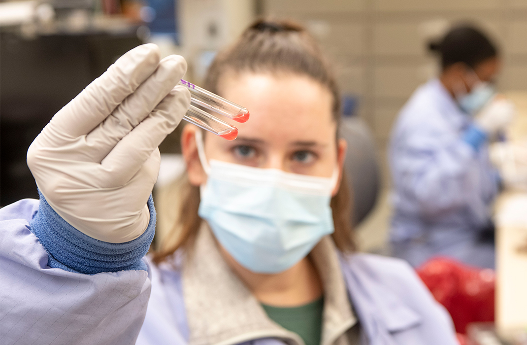 Blood bank specialists holds up sample vials