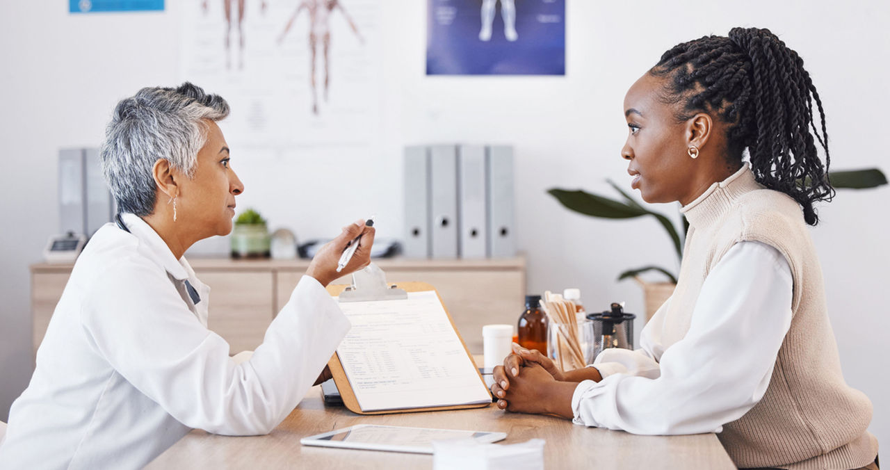 female african american patient talking to female doctor in office 