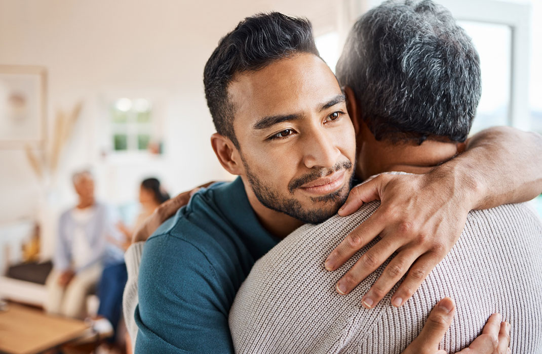 Man comforts family member coping with grief during the holidays.