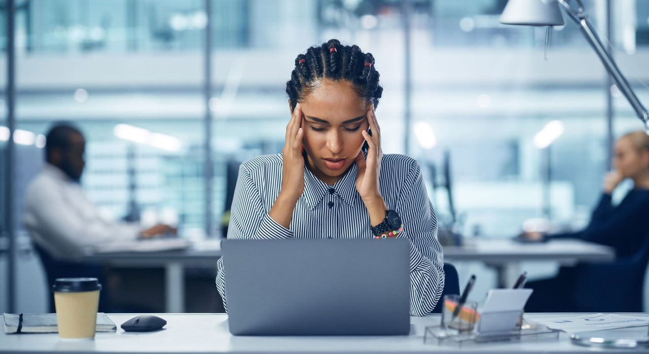 A stressed woman works at a computer.