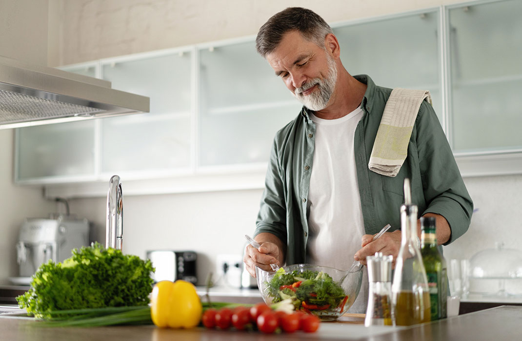 A man making a salad in the kitchen
