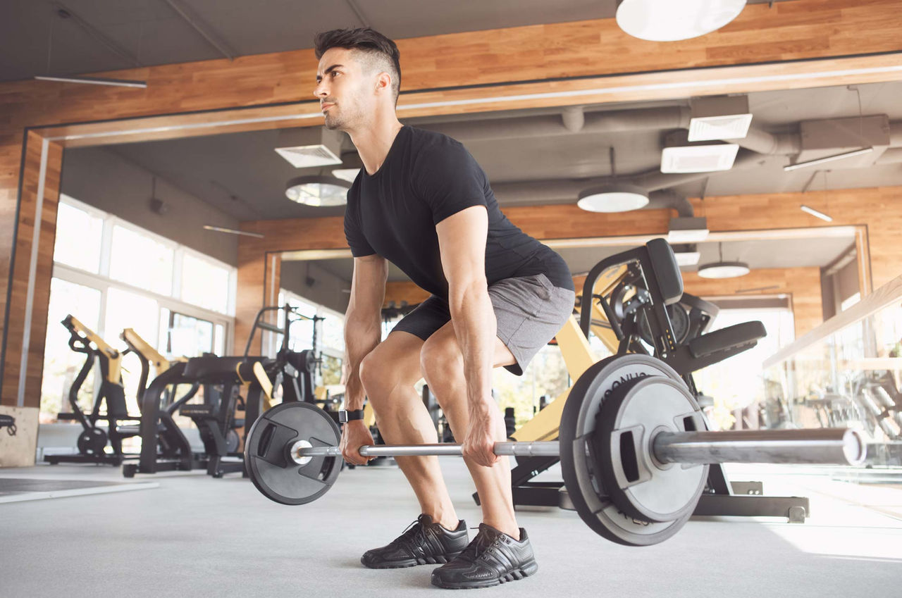 Understanding Olympic Weightlifting and Its Fitness Benefits A male athlete practices weightlifting
