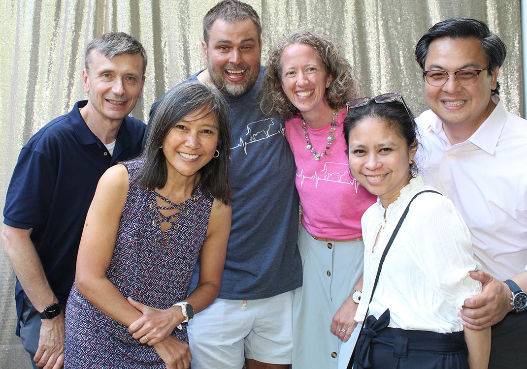 A group of three couples smiling for a photo