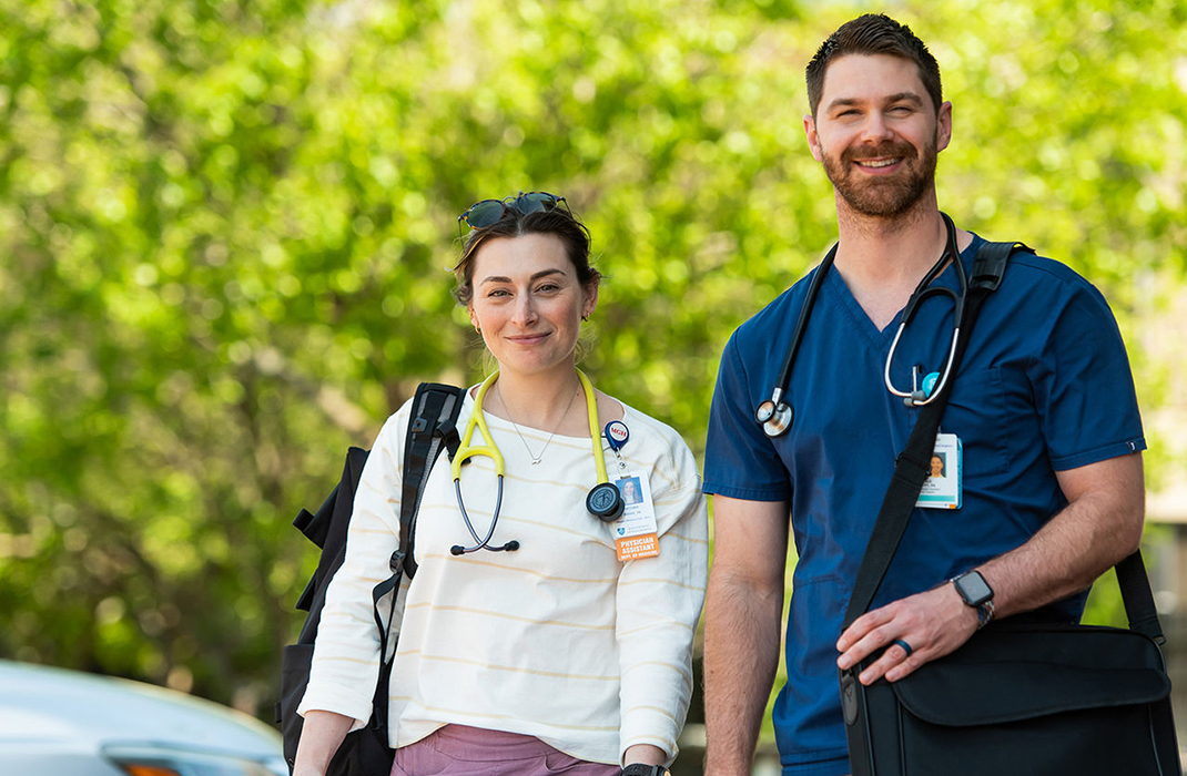 female and male medical providers carrying supplies outdoors