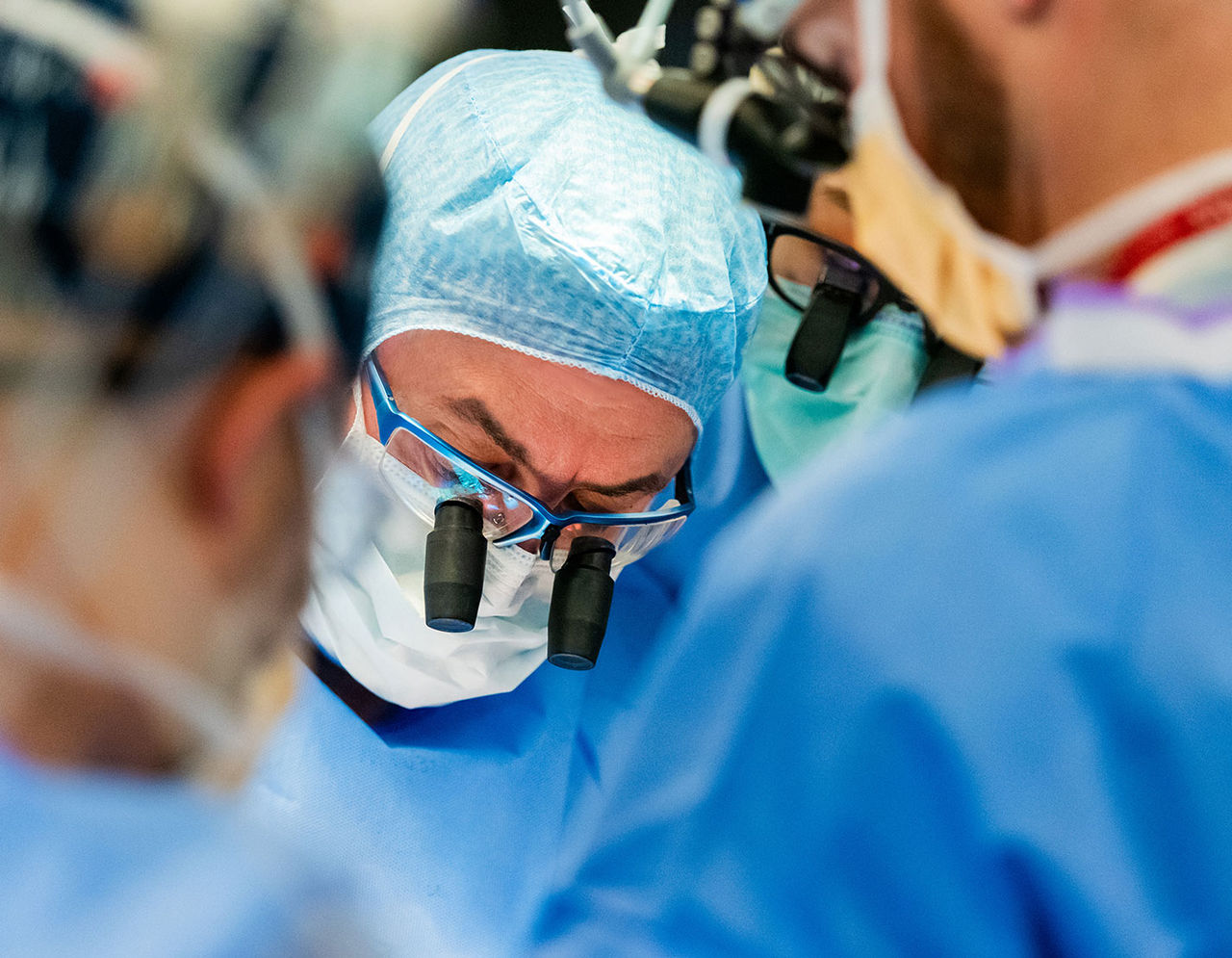 close up of heart care team performing surgery on patient in operating room