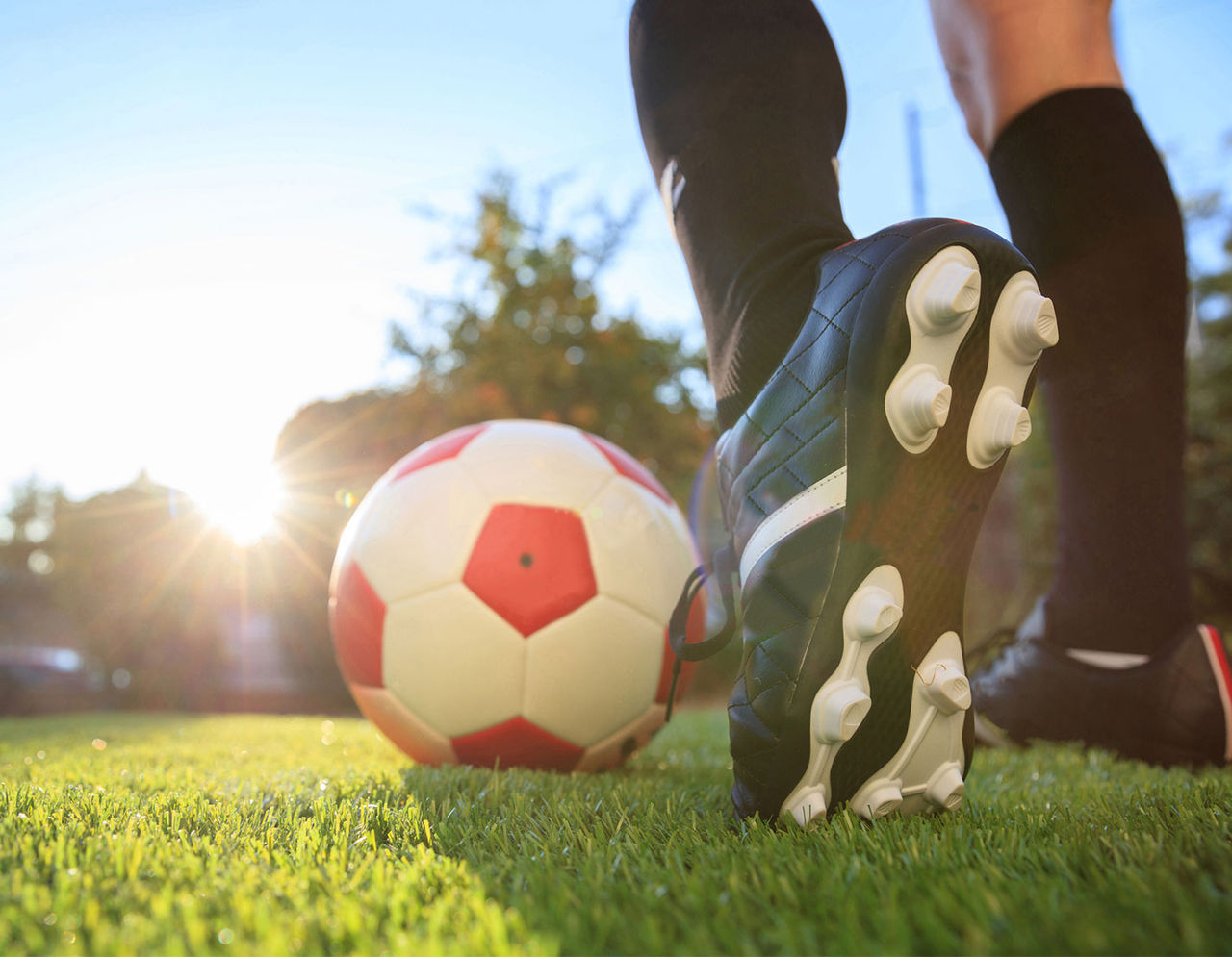 close up of soccer player's foot about to kick soccer ball on field